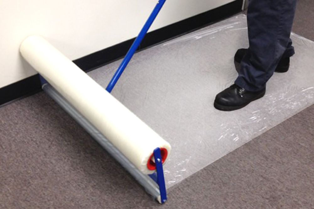 A person operates a roller to clean a floor, showcasing a protection and prevention service located in Aurora, CO.